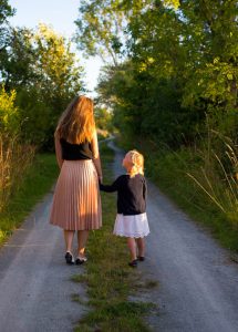 Woman and girl walking down path