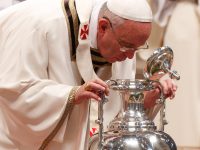 Pope Francis breathes over chrism oil during Holy Thursday chrism Mass in St. Peter’s Basilica at Vatican