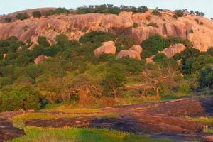 enchanted rock small wide hill water river lake grass day