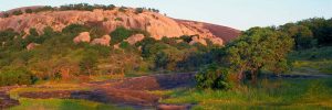 enchanted rock large wide hill water river lake grass day