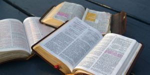 bible study three bibles highlighted on a black park table
